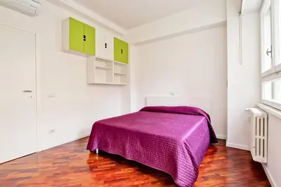 a bedroom with a purple bed and green cabinets at [Vaticano * * * * *] - Luxury Flat in Rome