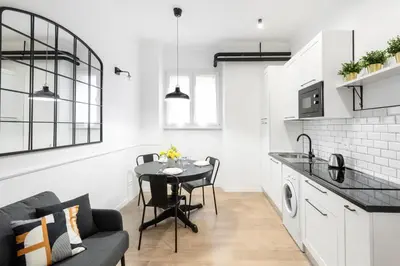 a kitchen and living room with a table and a couch at White flat Ground Floor in Rome