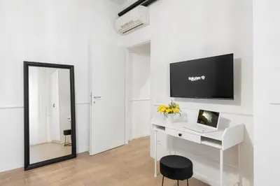 a white room with a desk with a computer and a mirror at White flat Ground Floor in Rome