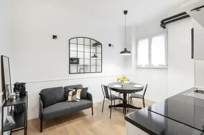 a kitchen and living room with a table and a chair at White flat Ground Floor in Rome