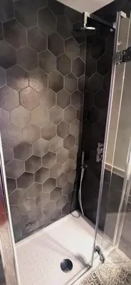 a shower with a black and gray tiled wall at Cosy penthouse loft with stunning view in Rome