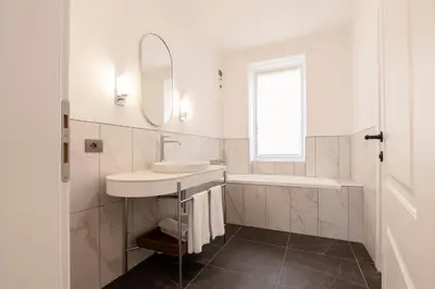 a white bathroom with a sink and a mirror at Be Mate Colosseo in Rome