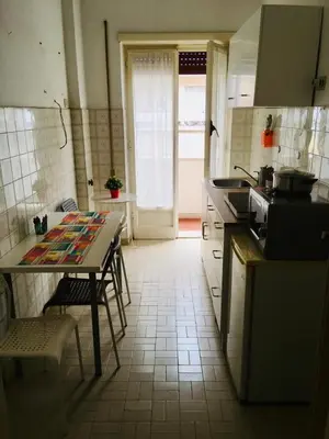 a kitchen with a table with chairs and a counter top at La mia casa di Roma in Rome
