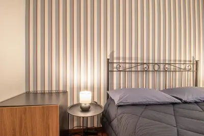 a bedroom with a bed and a table with a lamp at Praty Rooms in Rome