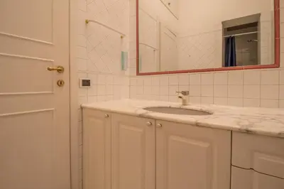a white bathroom with a sink and a mirror at Praty Rooms in Rome