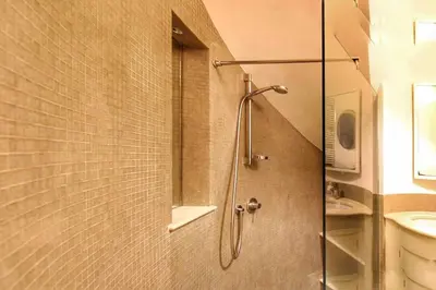 a shower with a glass door in a bathroom at Cozy Studio Flat in Trastevere by Yourhost in Rome