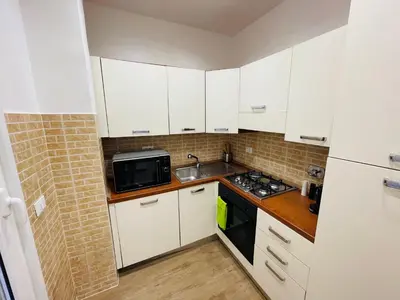 a small kitchen with white cabinets and a microwave at Home Vatican Oasis in Rome