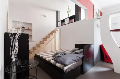 a living room with a couch and a stair case at Attic Vatican Flat - San Pietro in Rome