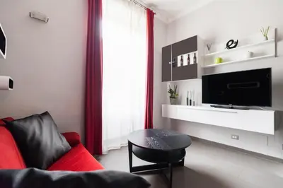 a living room with a red couch and a table at Attic Vatican Flat - San Pietro in Rome