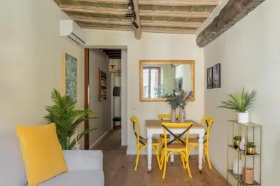 a dining room with a table and yellow chairs at iFlat The Heart of Monti in Rome