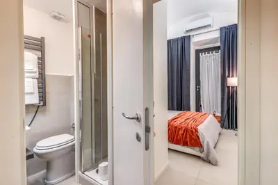 a bathroom with a toilet and a bed in a room at Studio Artis Piazza di Spagna in Rome