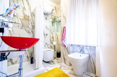 a bathroom with a red sink and a toilet at Cipro Roomy House - Vatican in Rome