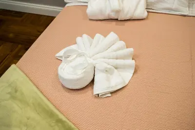a pair of white shoes with a bow on a bed at FORNACI 48 GUEST HOUSE in Rome