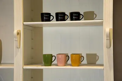 a row of coffee cups sitting on a shelf at FORNACI 48 GUEST HOUSE in Rome