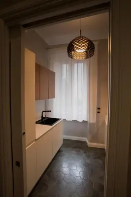 a kitchen with a sink and a pendant light at FORNACI 48 GUEST HOUSE in Rome