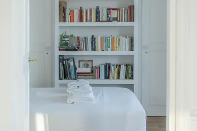 a room with a white book shelf with books at Aventino Terrace in Rome