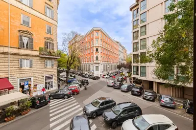 a city street with parked cars and buildings at Apt in the heart of the city in Rome