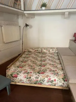 a small bedroom with a bed with a floral bedspread at Pantheon Loft - B in Rome