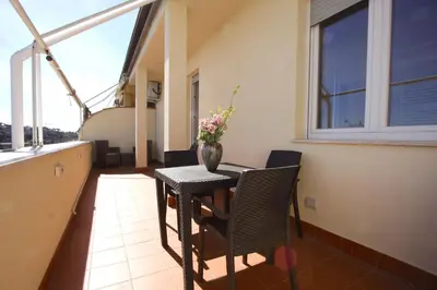 a balcony with a table with a vase of flowers on it at Sunny Flaminio Terrace Penthouse in Rome