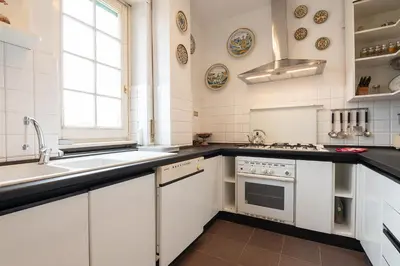 a white kitchen with a sink and a stove at La Terrazza di Paola San Giovanni in Rome