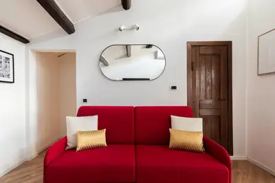 a red couch in a living room with a mirror at Trastevere Boutique Apartment in Rome