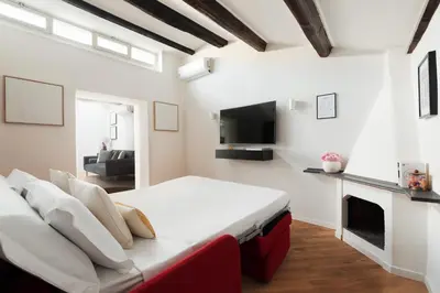 a white bedroom with a bed and a fireplace at Trastevere Boutique Apartment in Rome