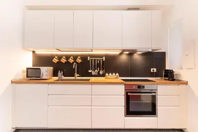 a kitchen with white cabinets and a sink and a microwave at Scipioni Holiday House in Rome
