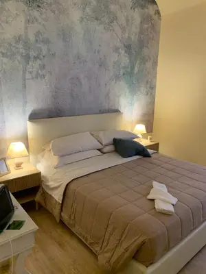 a bedroom with a large bed with a painting on the wall at Guest House VATICAN MUSEUMS PARVA DOMUS in Rome