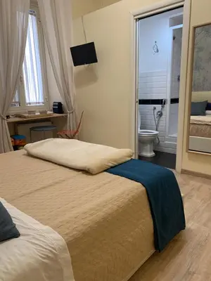 a bedroom with two beds and a bathroom with a toilet at Guest House VATICAN MUSEUMS PARVA DOMUS in Rome