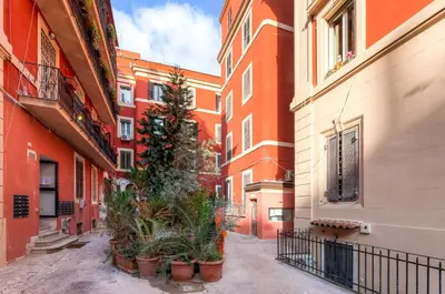 an alley in a city with buildings and potted plants at Guest House VATICAN MUSEUMS PARVA DOMUS in Rome