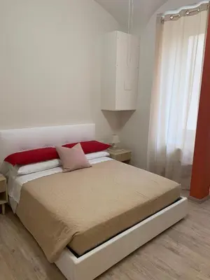 a bedroom with a bed with red and white at Guest House VATICAN MUSEUMS PARVA DOMUS in Rome