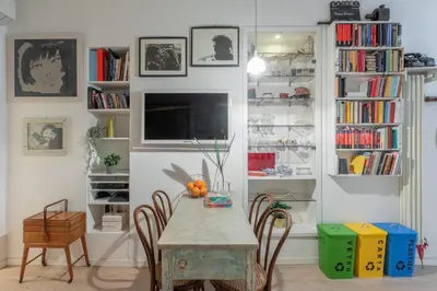 a dining room with a table and chairs and bookshelves at iFlat Cozy in Monti in Rome