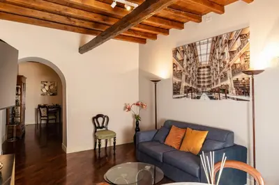 a living room with a blue couch and a table at Artemide Domus Romae in Rome