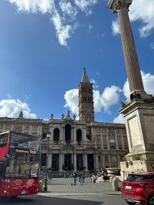 a red bus parked in front of a building with a clock tower at Dielle Apartments ROMA in Rome