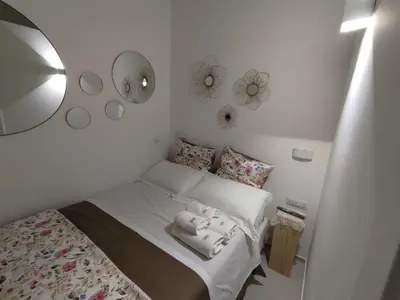 a small bedroom with a bed and a mirror at A CASA DEI ROMANI in Rome