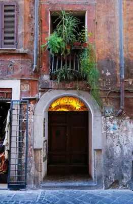 a building with a large wooden door with plants on it at Blue Navona Two Bedroom Apartment in Rome