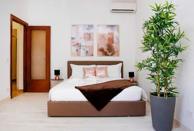 a bedroom with a bed and a potted plant at Charming Patio Apartment Trastevere in Rome