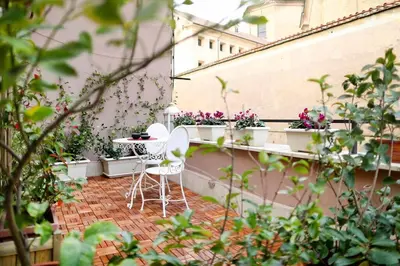 a patio with a table and chairs on a balcony at Terrace Modern Studio Trastevere in Rome