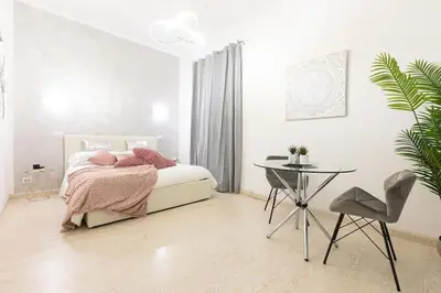 a white bedroom with a bed and a table at Romantic Jacuzzi Suite Trastevere in Rome