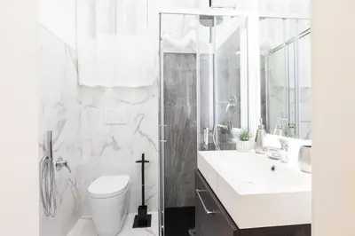a white bathroom with a toilet and a sink at Romantic Jacuzzi Suite Trastevere in Rome