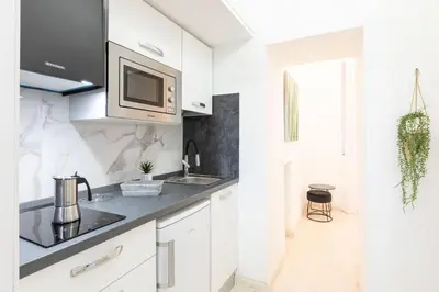 a white kitchen with a sink and a microwave at Romantic Jacuzzi Suite Trastevere in Rome