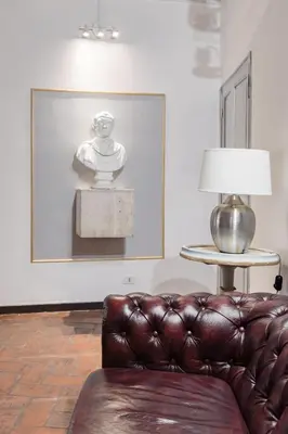 a living room with a leather couch and a picture at Decor Inspiration Apartment in Rome