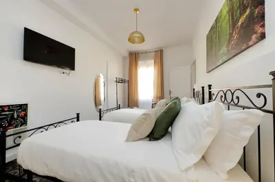 a bedroom with two white beds and a flat screen tv at YCH-Luminoso appartamento per 8 pax in Rome