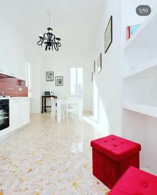 a living room with a red stool and a kitchen at YCH-Luminoso appartamento per 8 pax in Rome