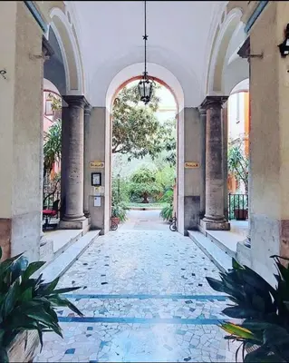 a hallway of a building with an arcade and plants at YCH-Luminoso appartamento per 8 pax in Rome