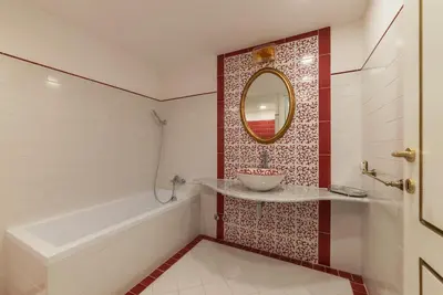 a bathroom with a sink and a tub and a mirror at GuestHost - Palazzo Altieri Elegant Apartment in Rome