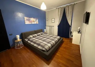 a bedroom with a bed and a blue wall at Window in the sky by Palazzo Senesi in Rome