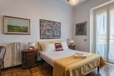 a white bedroom with a bed and a table at Charming Mazzini Apartment in Rome