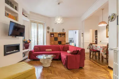 a living room with a red couch and a table at Charming Mazzini Apartment in Rome