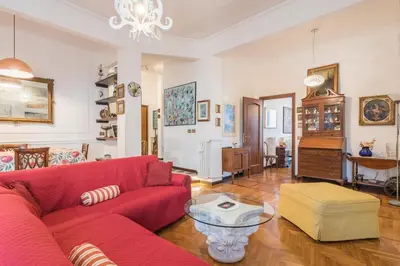 a living room with a red couch and a table at Charming Mazzini Apartment in Rome